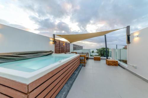 a hot tub on the balcony of a house at One Bay Residence Unit 15 - Penthouse with private roof top, jacuzzi and sea view in Grand-Baie