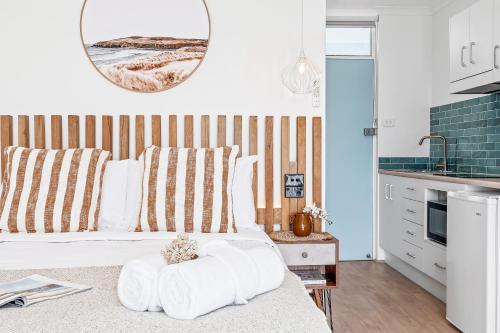 a bedroom with a bed with towels on it at Mollymook Motel in Mollymook