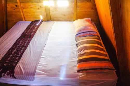 a bed with two pillows on it in a room at Sinuan Homestay 