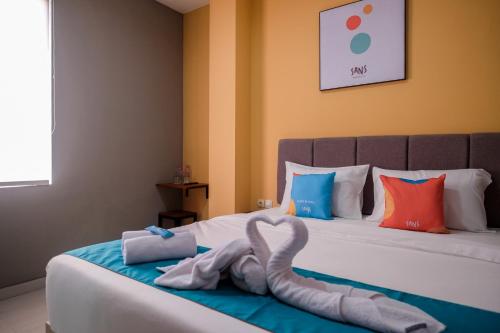 a bed with two swans made out of towels at Sans Hotel Fourth Loft Solo in Solo