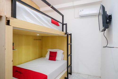 a bunk bed in a room with a tv at RedDoorz Hostel near Lawang Sewu Semarang in Kalibanteng-lor