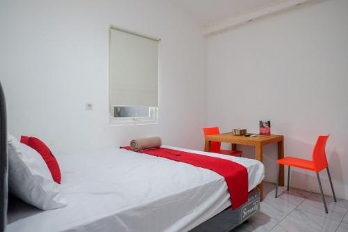 a bedroom with a bed and a table and chairs at RedDoorz Hostel near Lawang Sewu Semarang in Kalibanteng-lor