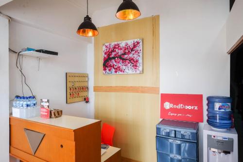 a room with a desk and a painting on the wall at RedDoorz Hostel near Lawang Sewu Semarang in Kalibanteng-lor