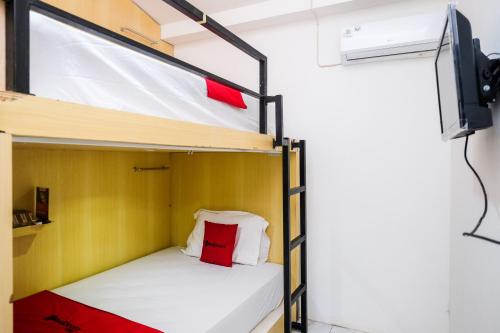a bunk bed in a room with a tv at RedDoorz Hostel near Lawang Sewu Semarang in Kalibanteng-lor