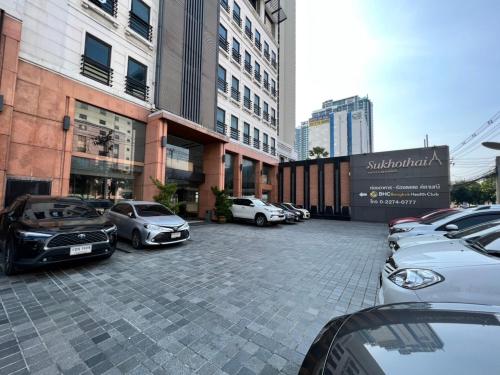 a parking lot with cars parked in front of buildings at Sukhothai Hotel and Residence Ratchada in Bangkok