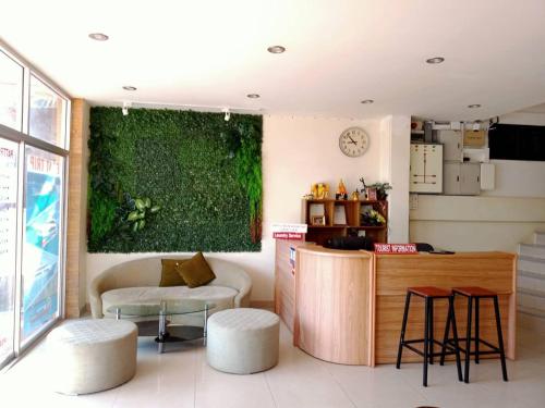 a room with a bar with stools and a green wall at Marina Seaview Krabi in Krabi town