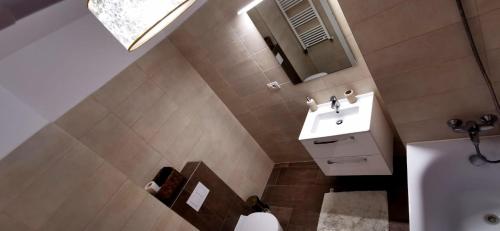 een badkamer met een wastafel en een spiegel bij Luxury apartment in Arad