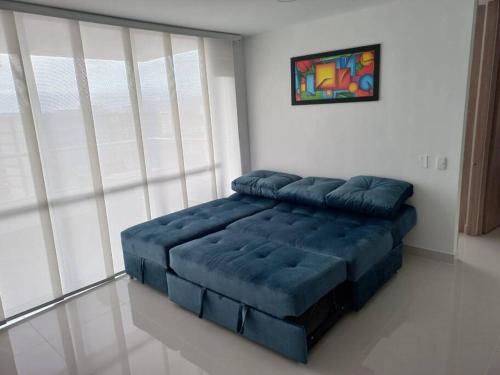 um quarto com uma cama azul num quarto em Apartamento en Ricaurte para descansar y disfrutar em Ricaurte