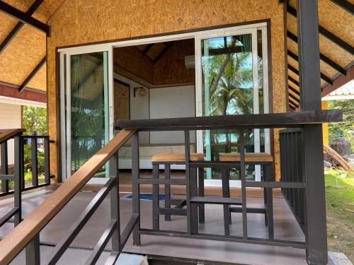 a balcony with glass doors and chairs on a house at Sunrise House in Ko Yao Noi