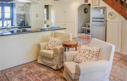 a kitchen with two chairs and a table and a refrigerator at Amazing Home In St Priest La Fougeres in La Coquille