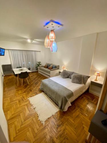 a bedroom with a bed and a living room at Monoambiente de diseño confortable -Puerto Madryn in Puerto Madryn
