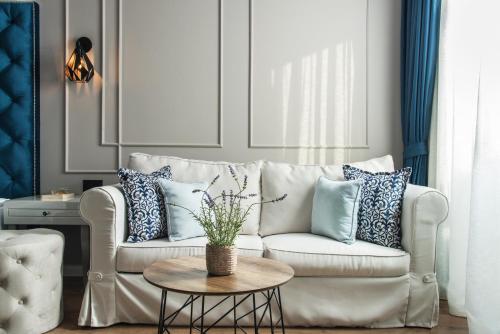 a living room with a white couch with blue pillows at Casa di Fiore SPA and Medical Hotel, Mineral Pools & Private Beach in Kranevo