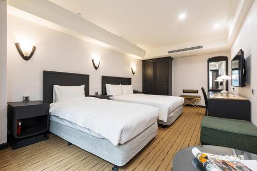 Habitación de hotel con 2 camas y sofá en Wowhappy Daan en Taipéi