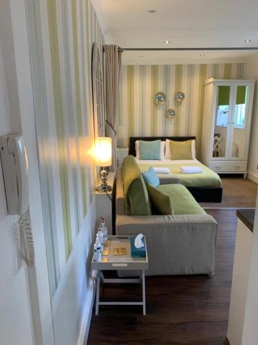 una sala de estar con un sofá y una cama en Between Piers, the stylish studio flat in Cannon place, en Brighton & Hove