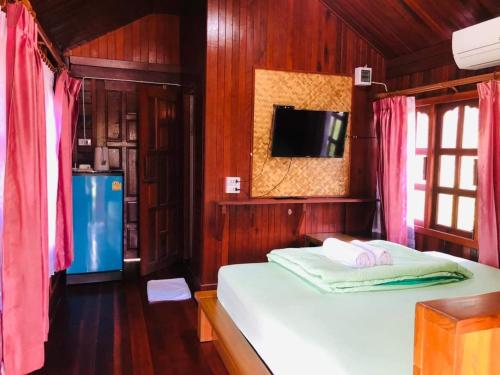 sypialnia z łóżkiem i telewizorem w obiekcie KOB SUK RESORT k7 , k10 w mieście Sichon