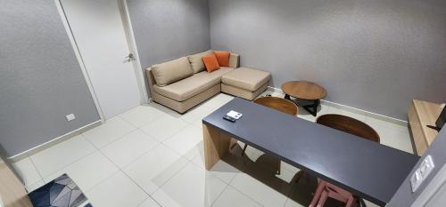 Cette petite chambre comprend un canapé et une table. dans l'établissement Anggerik I Liberty I City Homestay, à Shah Alam