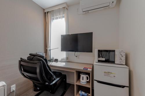 a room with a desk with a computer and a chair at HOTEL R9 The Yard Shikokuchuo in Shikokuchuo