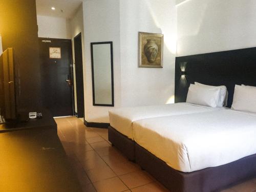 a hotel room with a large bed and a mirror at Flamingo Hotel By The Lake, Kuala Lumpur in Kuala Lumpur