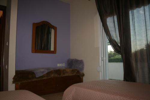 a bedroom with two beds and a mirror and a window at KIKI Stegna in Archangelos