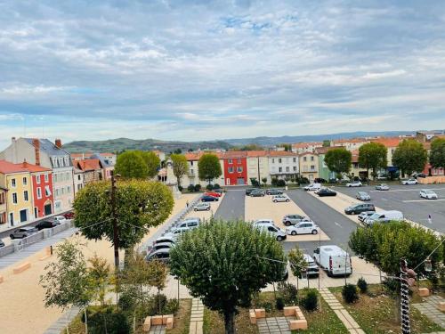 a city street with cars parked in a parking lot at Cristal 2 in Issoire