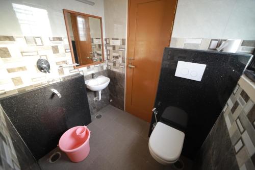 a bathroom with a white toilet and a sink at Majestic Hotel in Madurai