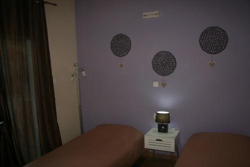 a bedroom with two beds and a lamp on a night stand at KIKI Stegna in Archangelos