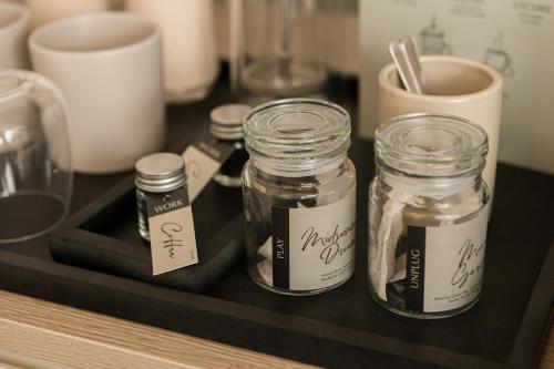 three mason jars sitting on a tray on a counter at YANH Ratchawat Hotel in Bangkok