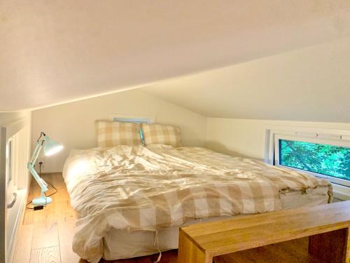 Schlafzimmer mit einem Bett und einem Fenster in der Unterkunft Tiny house - idyllic accommodation in Grimstad