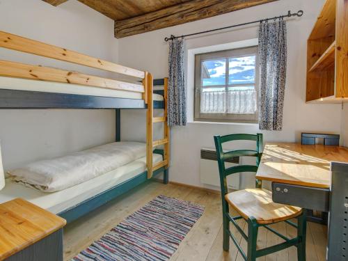 a bedroom with bunk beds and a table and a desk at Apartment in Lienz with a balcony in Obernussdorf