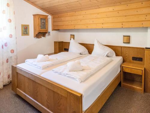 Apartment in Bad Kleinkirchheim ski resort في باد كلينكيرشهايم: سرير كبير عليه أغطية ووسائد بيضاء
