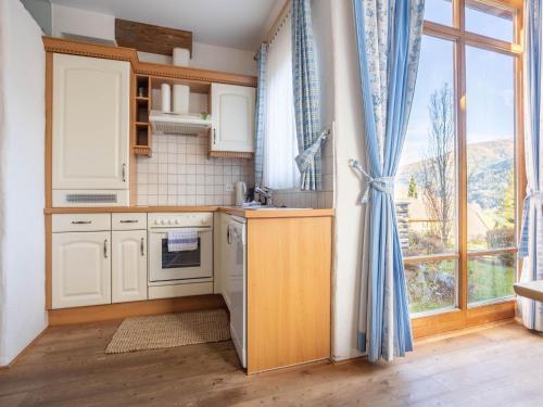a kitchen with white cabinets and a large window at Apartment in Bad Kleinkirchheim Ski Area in Bad Kleinkirchheim