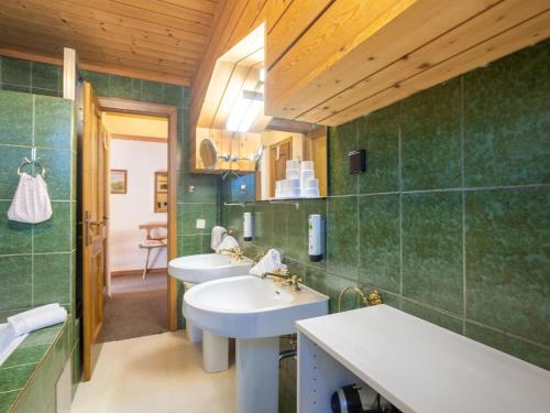 Apartment in Bad Kleinkirchheim ski resort في باد كلينكيرشهايم: حمام به مغسلتين وبلاط أخضر