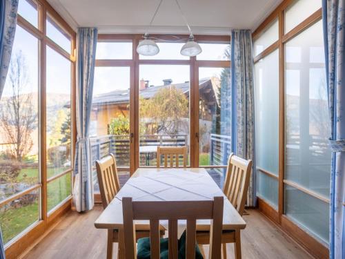 a dining room with a table and chairs and large windows at Apartment in Bad Kleinkirchheim Ski Area in Bad Kleinkirchheim