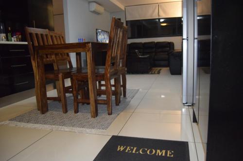 ウィントフークにあるScenic Apartment in Windhoek City Centreの椅子が置かれたキッチンと床に置かれた歓迎のサイン