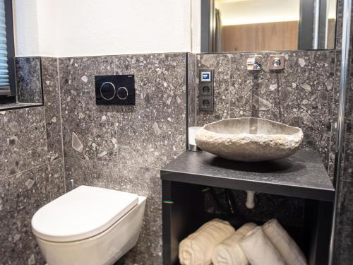 La salle de bains est pourvue d'un lavabo, de toilettes et d'un comptoir. dans l'établissement Chalet in Wald im Pinzgau near Krimml Falls, à Wald im Pinzgau