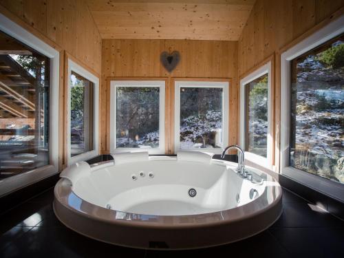 a large bath tub in a room with windows at Chalet Alpenpark Turracherhöhe 4 in Turracher Hohe