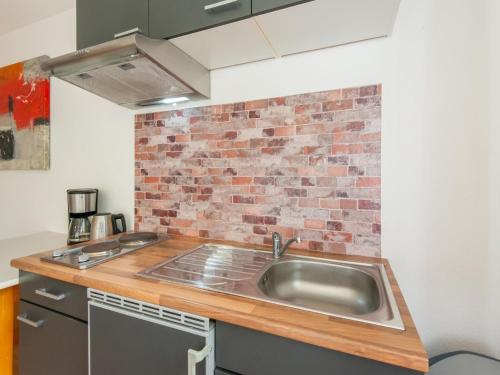 a kitchen with a sink and a brick wall at Chalet in Sibratsgfäll near Ski Slopes in Sibratsgfäll