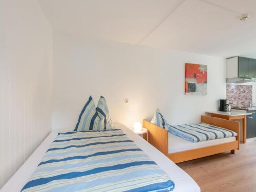 een slaapkamer met een bed met blauwe en witte gestreepte lakens bij Picturesque studio in Sibratsgf ll with garden in Sibratsgfäll
