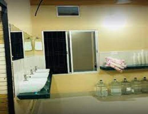een badkamer met 3 wastafels en een grote spiegel bij Hotel Firdous Palace, Surajpur Chhattisgarh 
