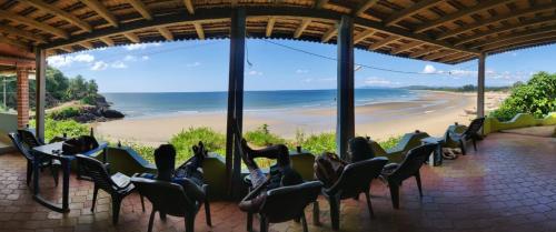 ゴカルナにあるPoornima Beach Stayのビーチの景色を望む椅子付きの客室です。