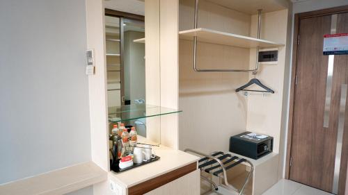 a small kitchen with a glass counter with a refrigerator at Hotel Ayola Sunrise Mojokerto in Mojokerto