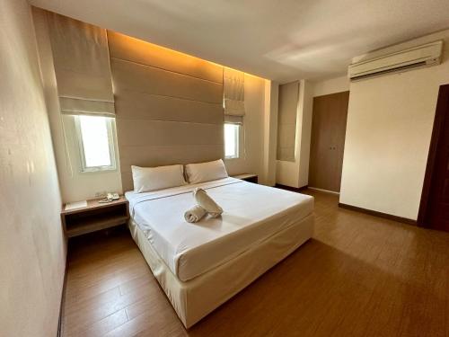 una camera da letto con un grande letto bianco e un telefono di Calypzo 2 Ratchada 20 a Bangkok