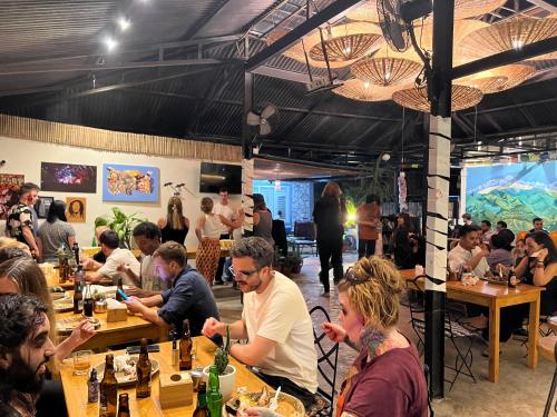 a group of people sitting at tables in a restaurant at Pokhara Backpackers Hostel in Pokhara
