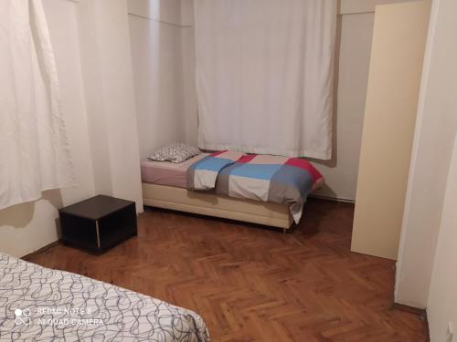 a small room with two beds and a window at Uncular Flat 3+1 in Istanbul
