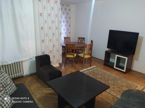 a living room with a table and a tv at Uncular Flat 3+1 in Istanbul
