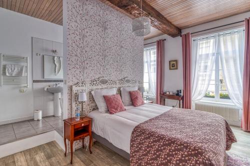 ブローニュ・シュル・メールにあるLa Boulonnaiseのベッドルーム1室(ピンクの枕が付いた大型ベッド1台付)
