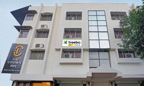 un edificio blanco alto con un letrero. en Itsy By Treebo - Crown Inn en Pune