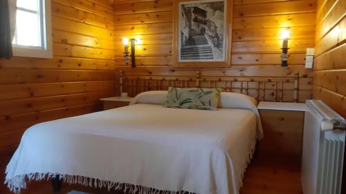 1 dormitorio con 1 cama blanca en una habitación de madera en Casitas La Purísima Lavanda, en Requena