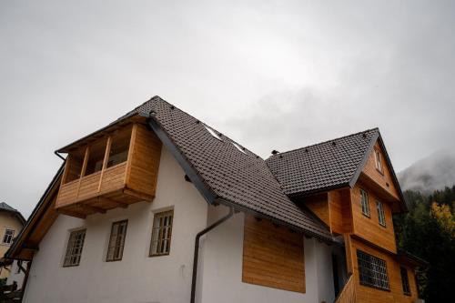 a house with a wooden roof on top of it at House Leska in Kranjska Gora