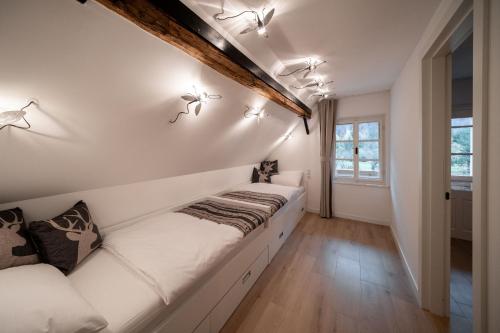 a white room with a long white couch at House Leska in Kranjska Gora
